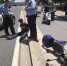 图说：小偷偷电瓶被抓，坐在滚烫的地上等待被带上警车。来源：警民直通车-上海 - 新浪上海
