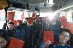公益专线巴士上手拿新春对联和平安帖的学生们。 - 上海交通大学