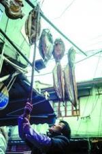 杨浦区一条老弄堂里一位阿姨将腌制好的鱼挂在外面风干。 - 新浪上海