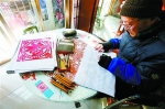 朱金辉老人正在伏案创作剪纸。姜辉辉　摄 - 新浪上海