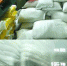 白色编织袋内装大米，旁边是一摞摞品牌贴纸。 - 新浪上海