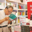 一位老年读者在文学专区精心选购自己心仪的图书。 - 新浪上海