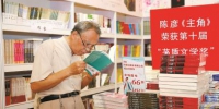 一位老年读者在文学专区精心选购自己心仪的图书。 - 新浪上海